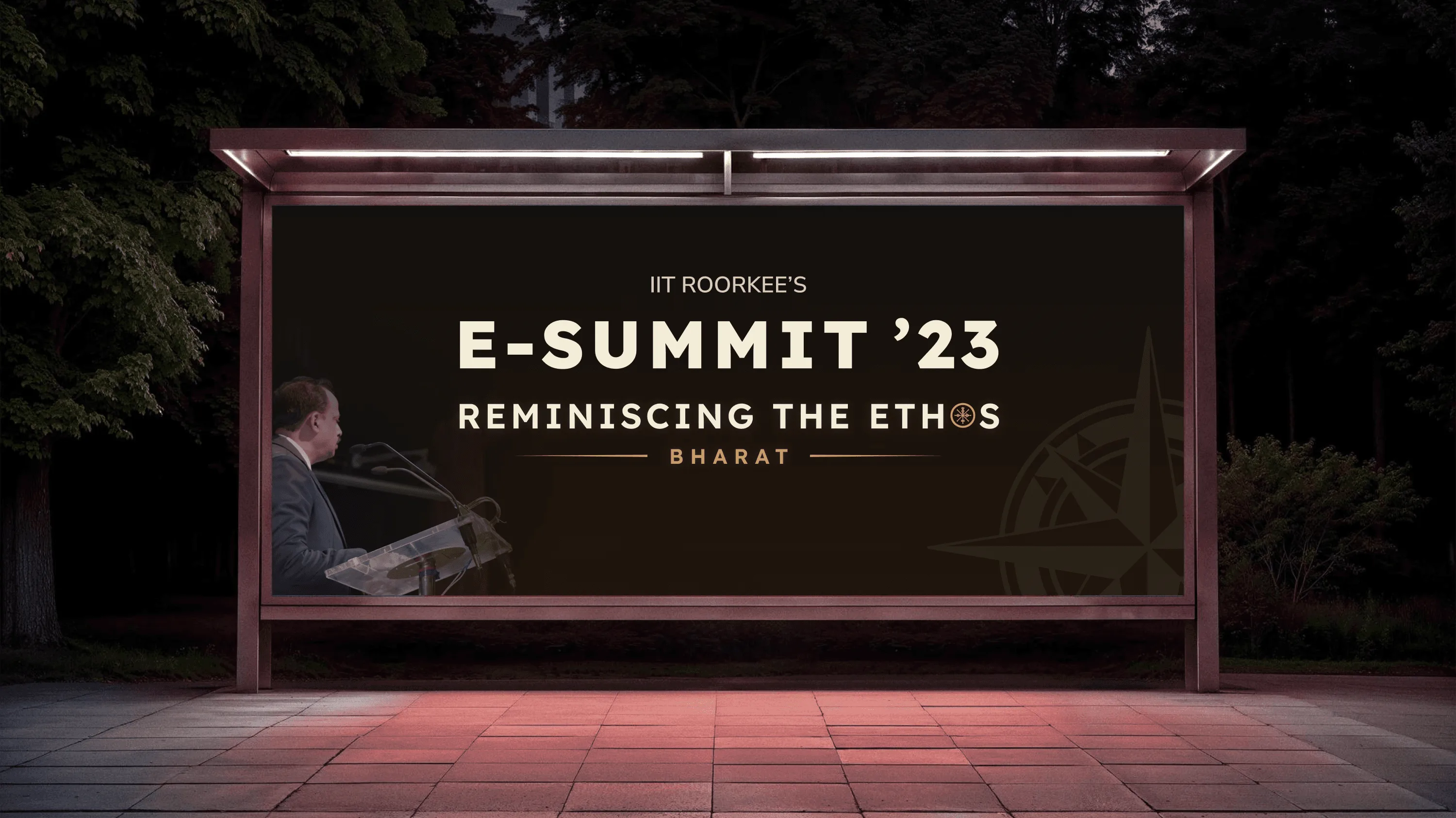 Night-time bus shelter billboard showing IIT Roorkee's E-Summit '23 Reminiscing the Ethos Bharat poster with a speaker at a podium